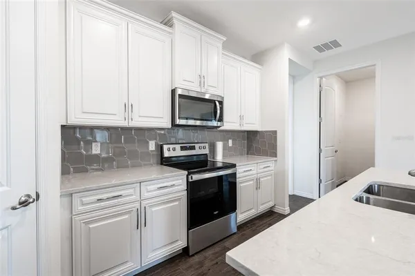 a kitchen with white cabinets and white appliances