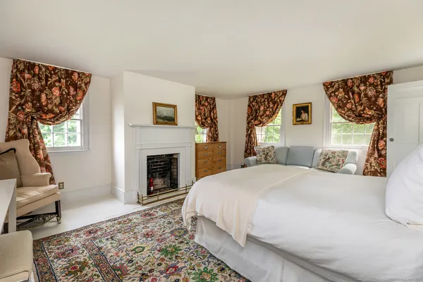 a spacious bedroom with a bed and a fireplace