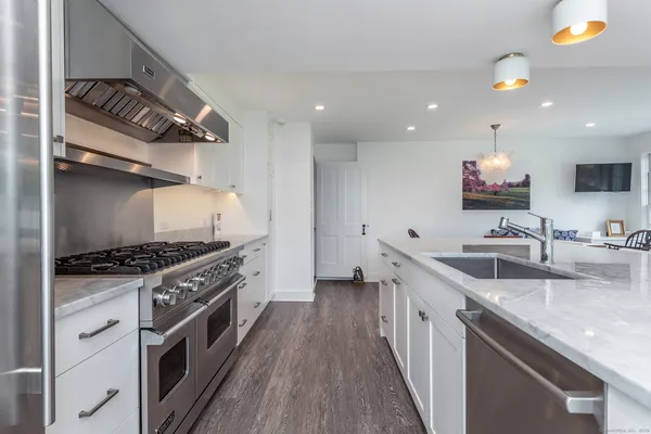 a kitchen with stainless steel appliances granite countertop a stove a sink and a refrigerator