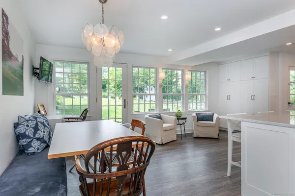 a view of a dining room with furniture a chandelier and wooden floor
