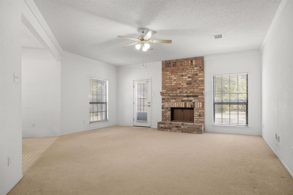 162 Warren Road Lorena, TX 76655 - Photo 9 of 39 Spacious living area featuring a brick fireplace, ceiling fan, and multiple windows with blinds