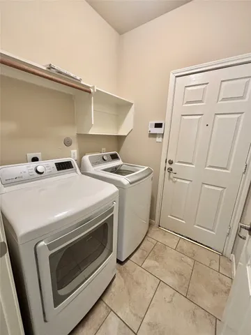 a view of a hallway with granite countertop a couch and a chandelier