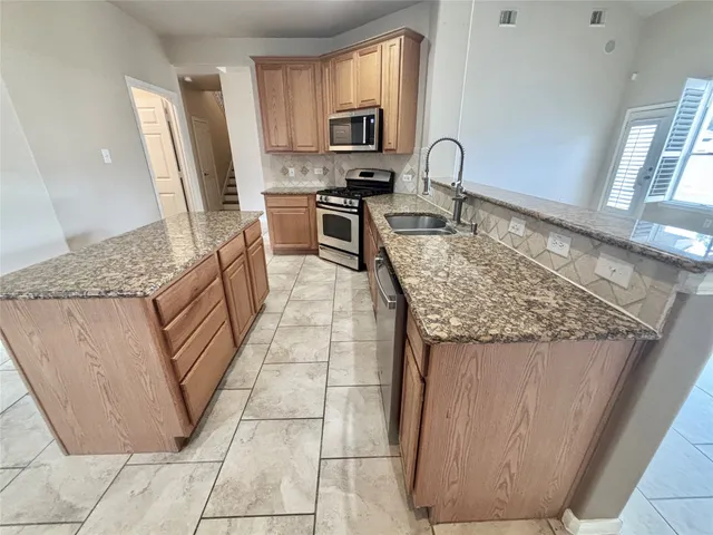 a kitchen with stainless steel appliances granite countertop a sink stove and cabinets