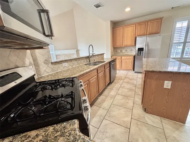 a view of an empty room and a kitchen