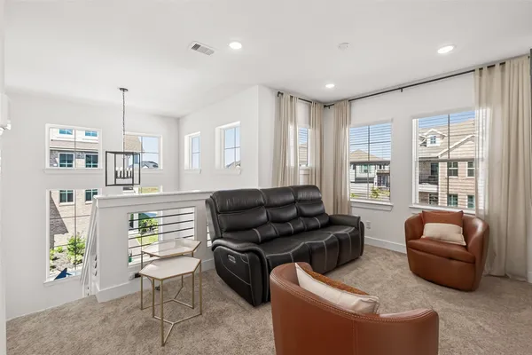 a living room with furniture a ceiling fan and a window