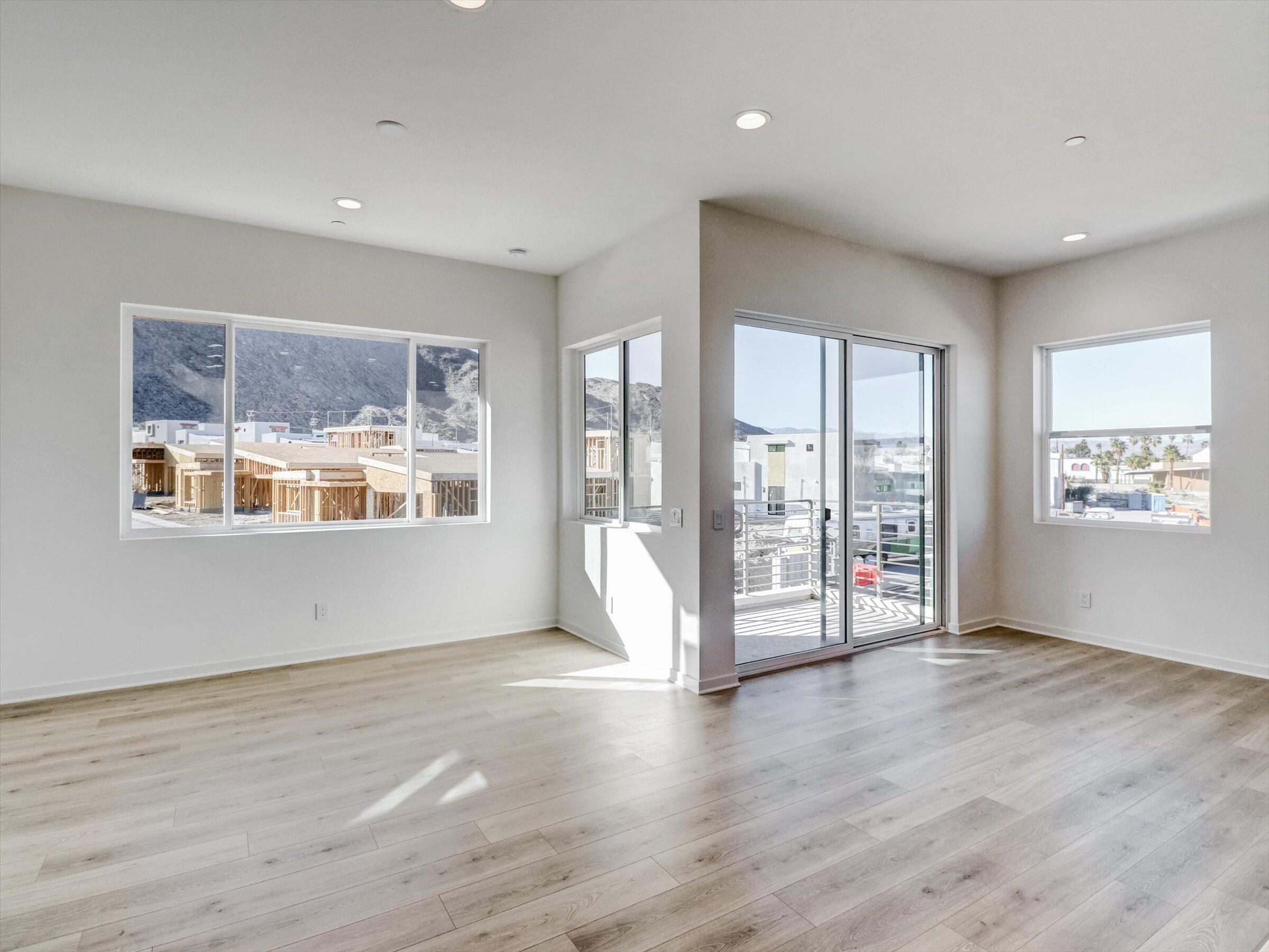 718 Obsidian Loop East, Unit 73 Palm Springs, CA 92264 - Photo 11 of 49 a view of an empty room with a window and wooden floor