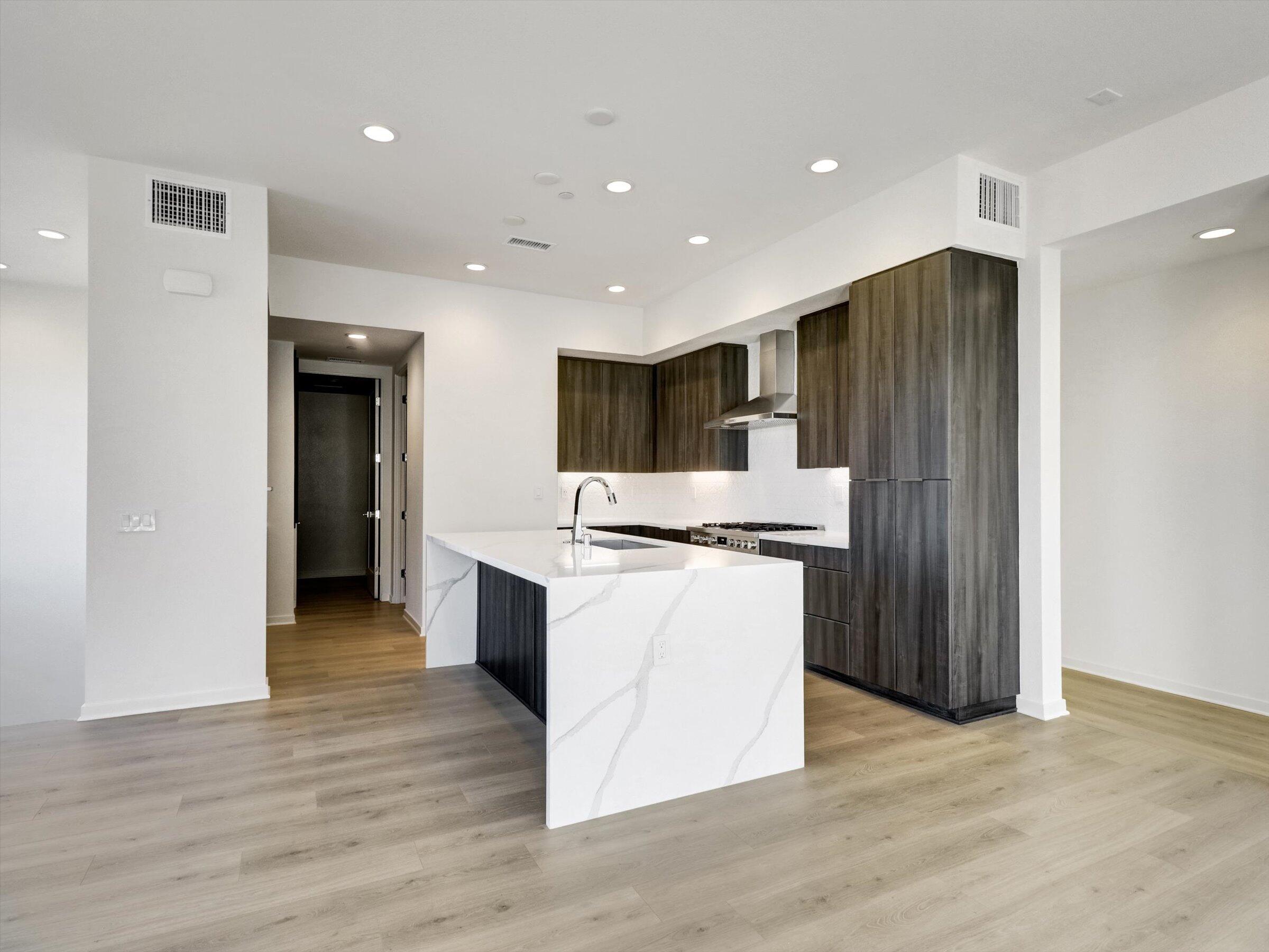 718 Obsidian Loop East, Unit 73 Palm Springs, CA 92264 - Photo 13 of 49 a kitchen with stainless steel appliances granite countertop a refrigerator and a stove top oven