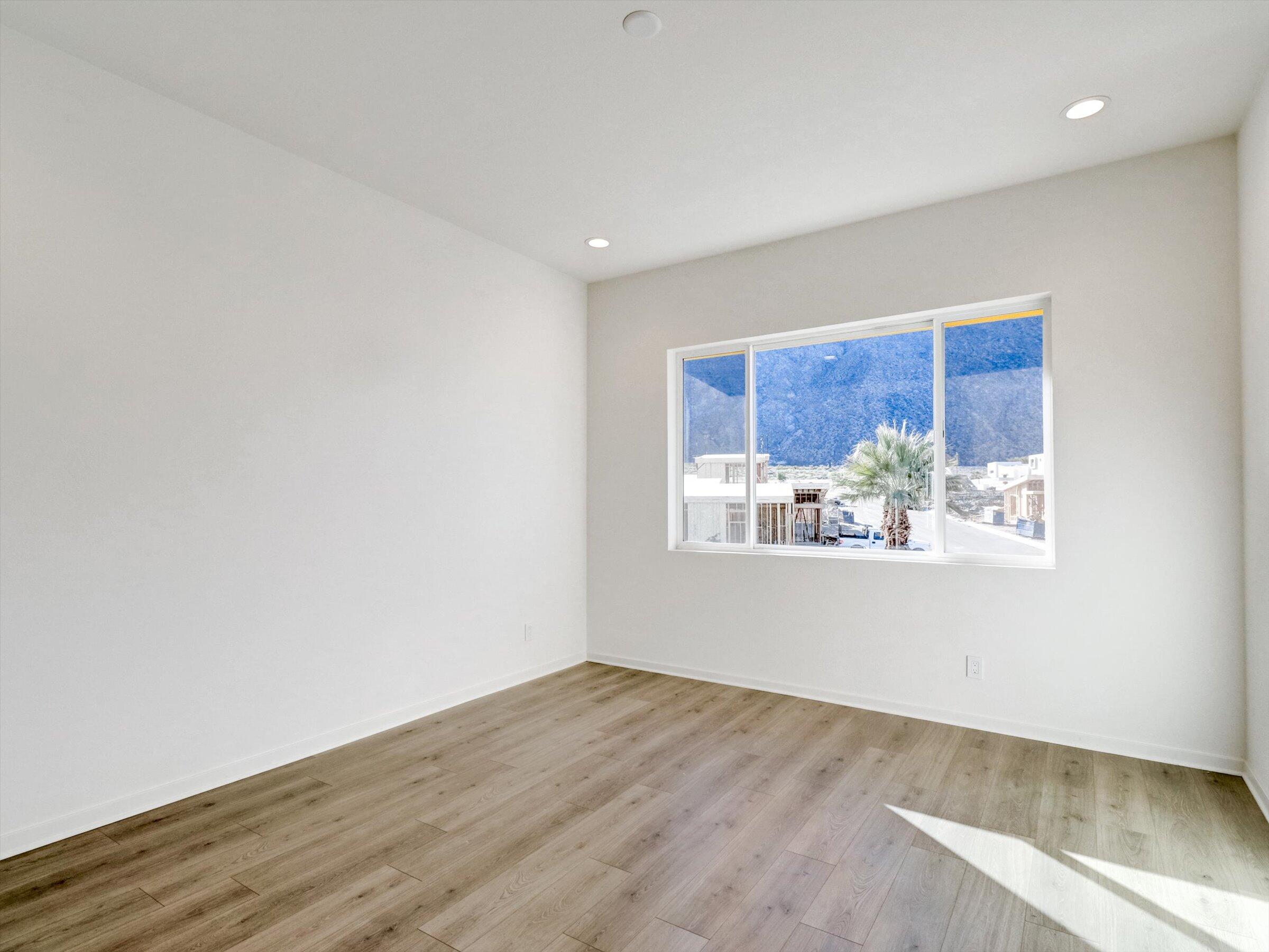718 Obsidian Loop East, Unit 73 Palm Springs, CA 92264 - Photo 22 of 49 an empty room with wooden floor and a window