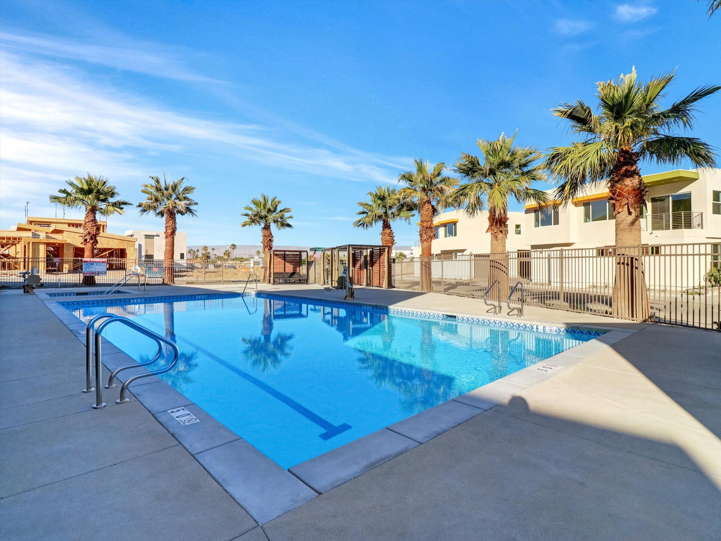 718 Obsidian Loop East, Unit 73 Palm Springs, CA 92264 - Photo 35 of 49 a view of a swimming pool with a lounge chair