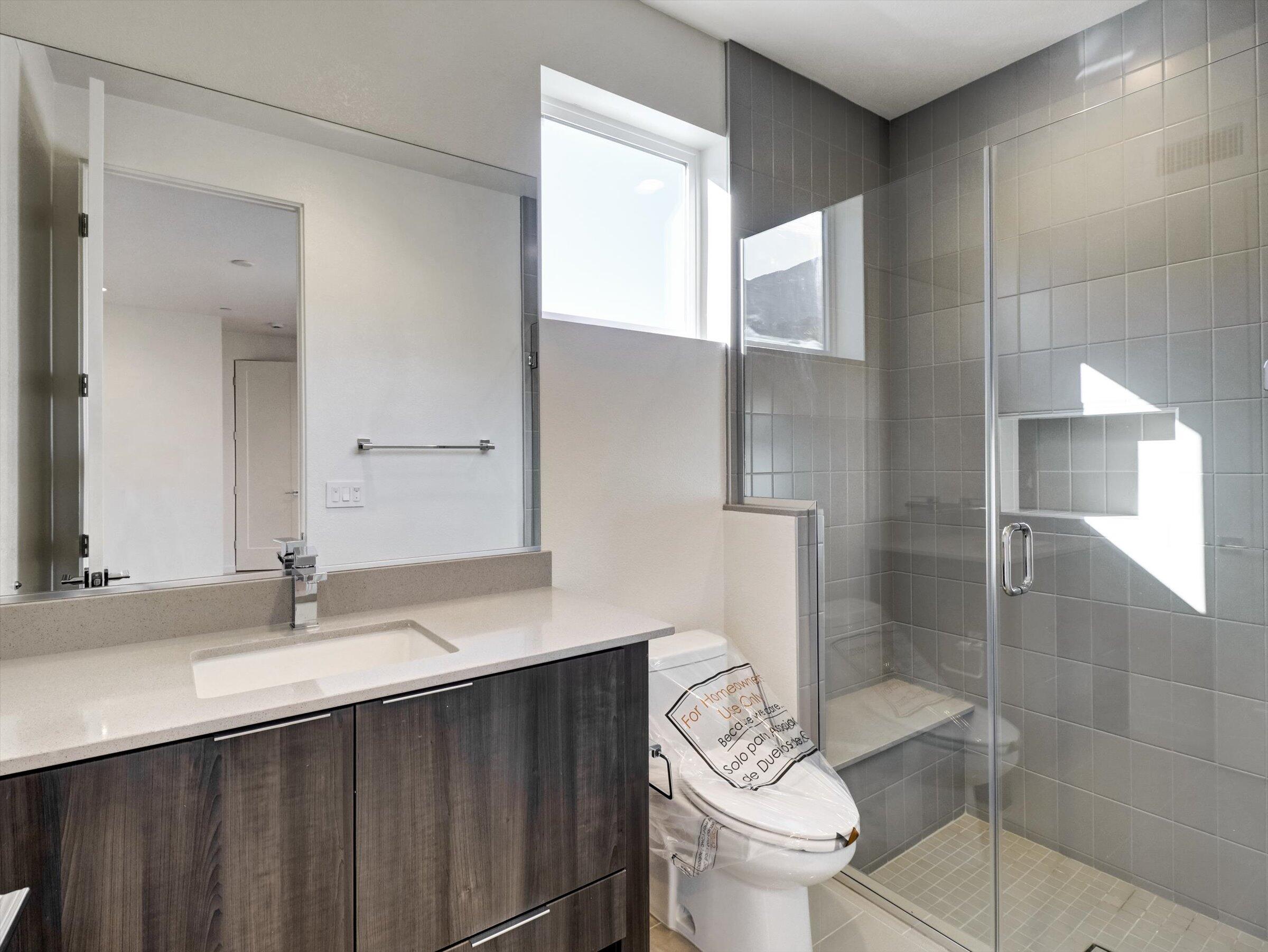 718 Obsidian Loop East, Unit 73 Palm Springs, CA 92264 - Photo 7 of 49 a bathroom with a sink a toilet and shower