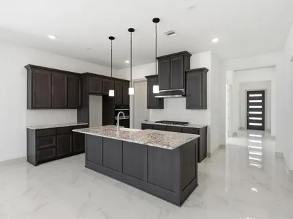 a large kitchen with stainless steel appliances kitchen island granite countertop a stove a sink and a refrigerator
