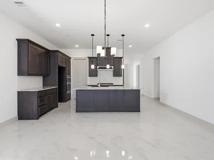 a large kitchen with a large counter top cabinets and stainless steel appliances