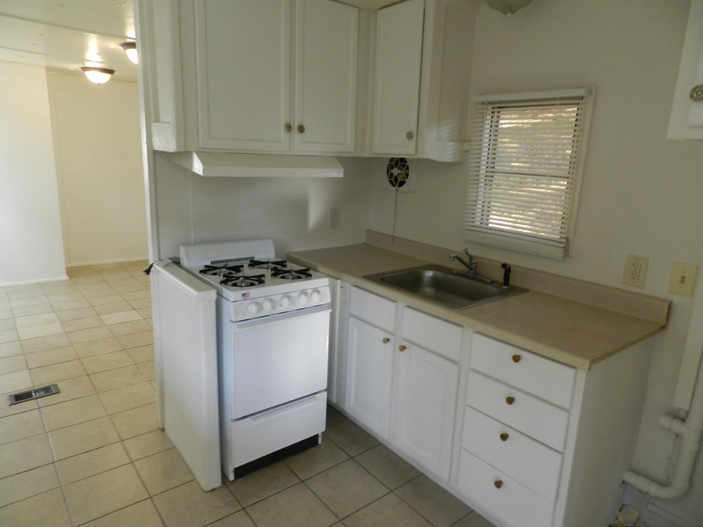 17653 Vierra Canyon Road Salinas, CA 93907 - Photo 3 of 100 a kitchen with granite countertop white cabinets and white appliances