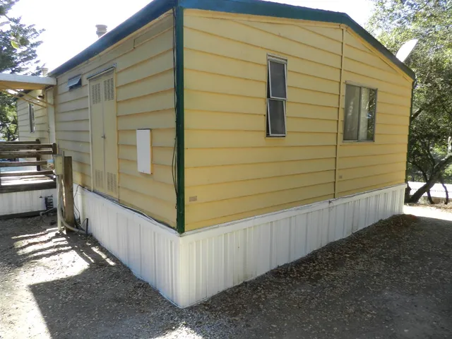 a view of a kitchen with wooden floor electronic appliances and a window