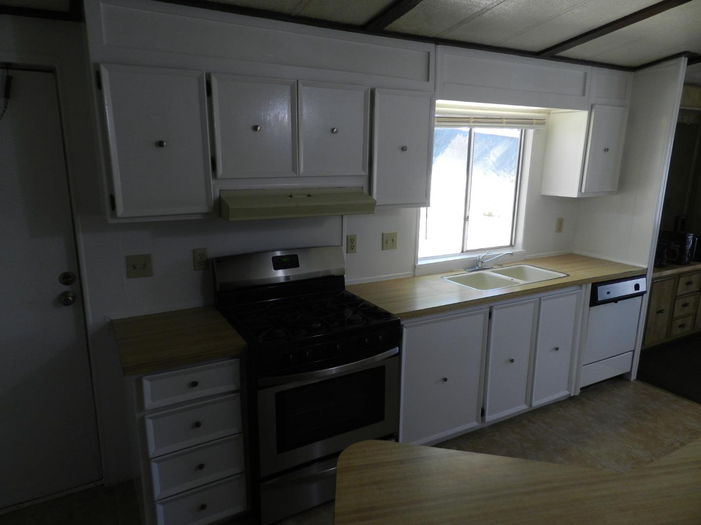 17653 Vierra Canyon Road Salinas, CA 93907 - Photo 58 of 100 a kitchen with granite countertop white cabinets and black appliances
