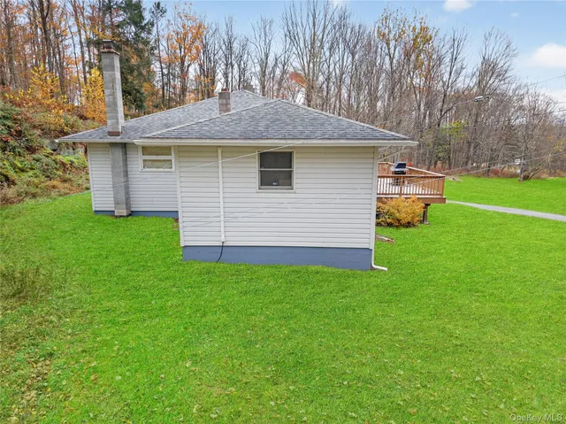 a backyard of a house with a yard and outdoor seating