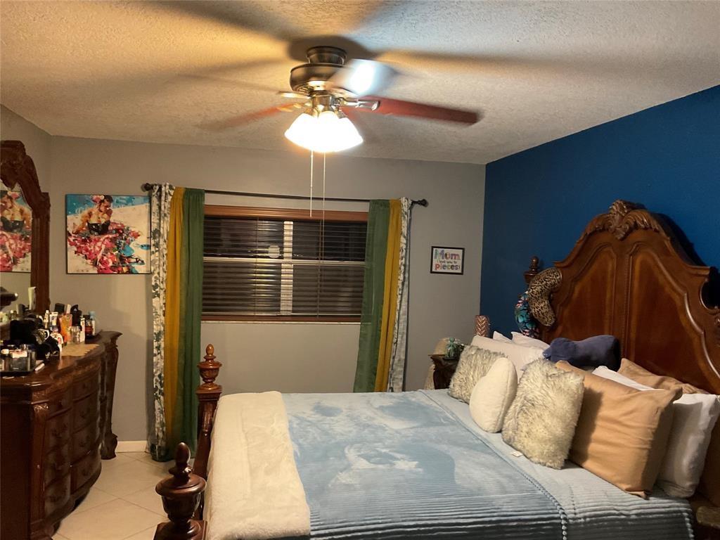 4770 Northwest 85th Avenue Lauderhill, FL 33351 - Photo 18 of 44 a bedroom with a bed and a chandelier