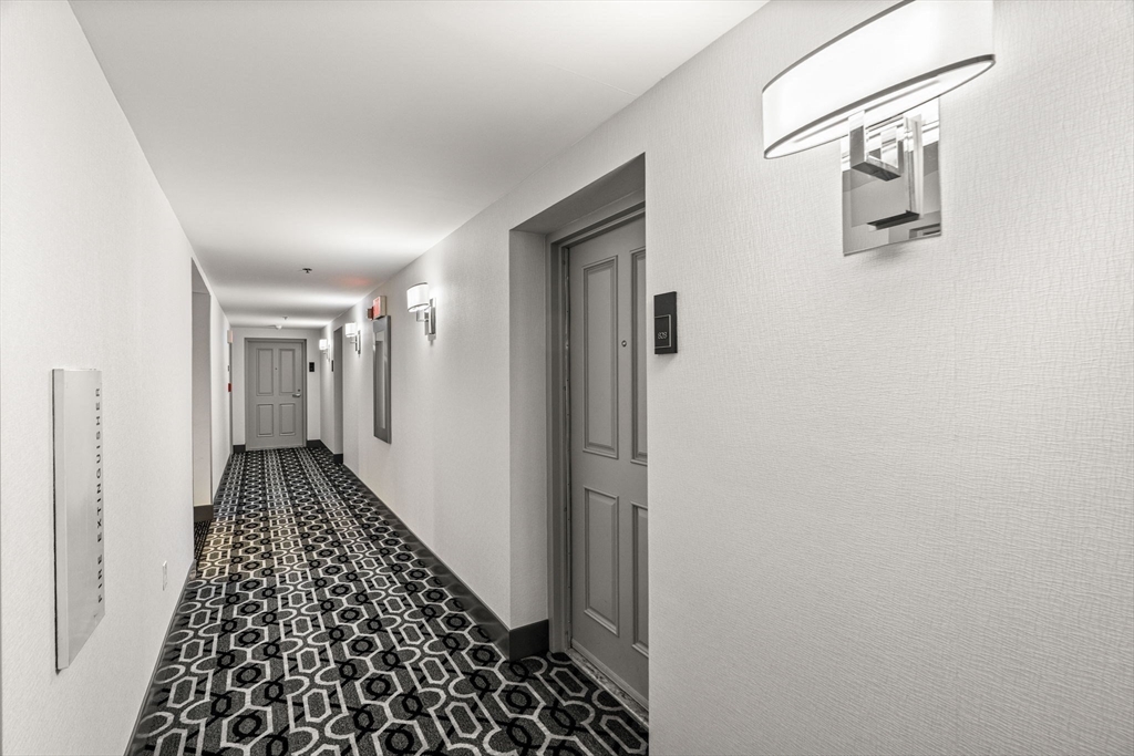 10 Museum Way, Unit 828 Cambridge, MA 02141 - Photo 28 of 36 a view of a hallway with wooden floor and a bathroom