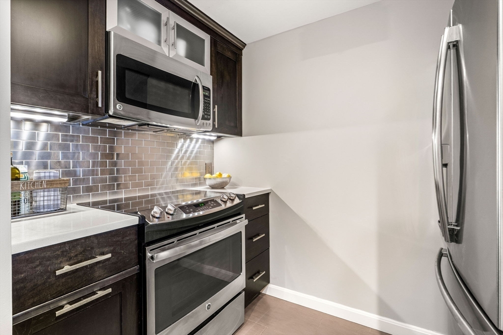 10 Museum Way, Unit 828 Cambridge, MA 02141 - Photo 5 of 36 a kitchen with granite countertop a sink stove and microwave