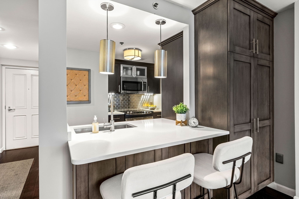 10 Museum Way, Unit 828 Cambridge, MA 02141 - Photo 10 of 36 a kitchen with a table chairs and a refrigerator