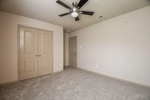 an empty room with closet and windows