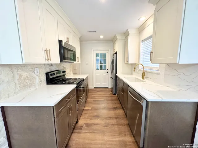 a large kitchen with a stove and a sink