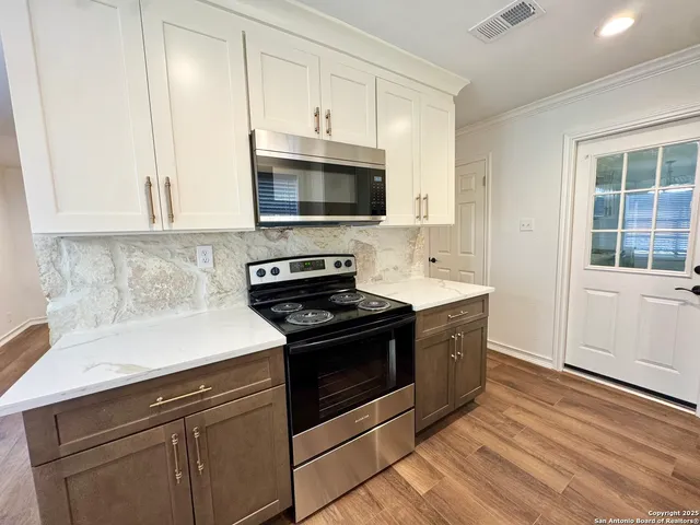 a kitchen with stainless steel appliances granite countertop a sink and a stove