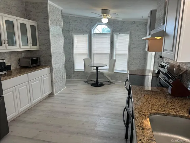 a kitchen with sink and mirror