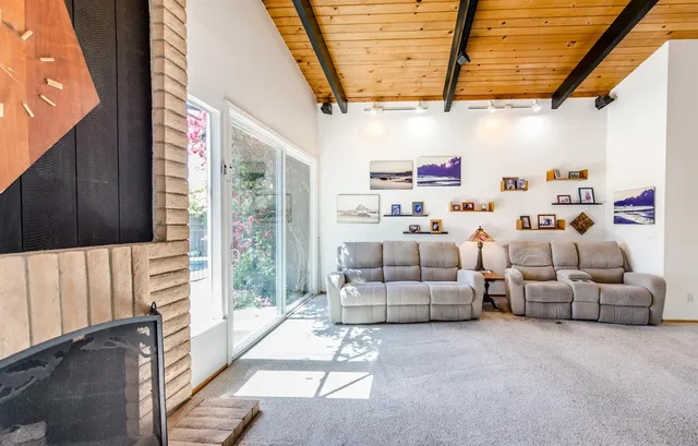 a view of a backyard with table and chairs potted plants and large tree