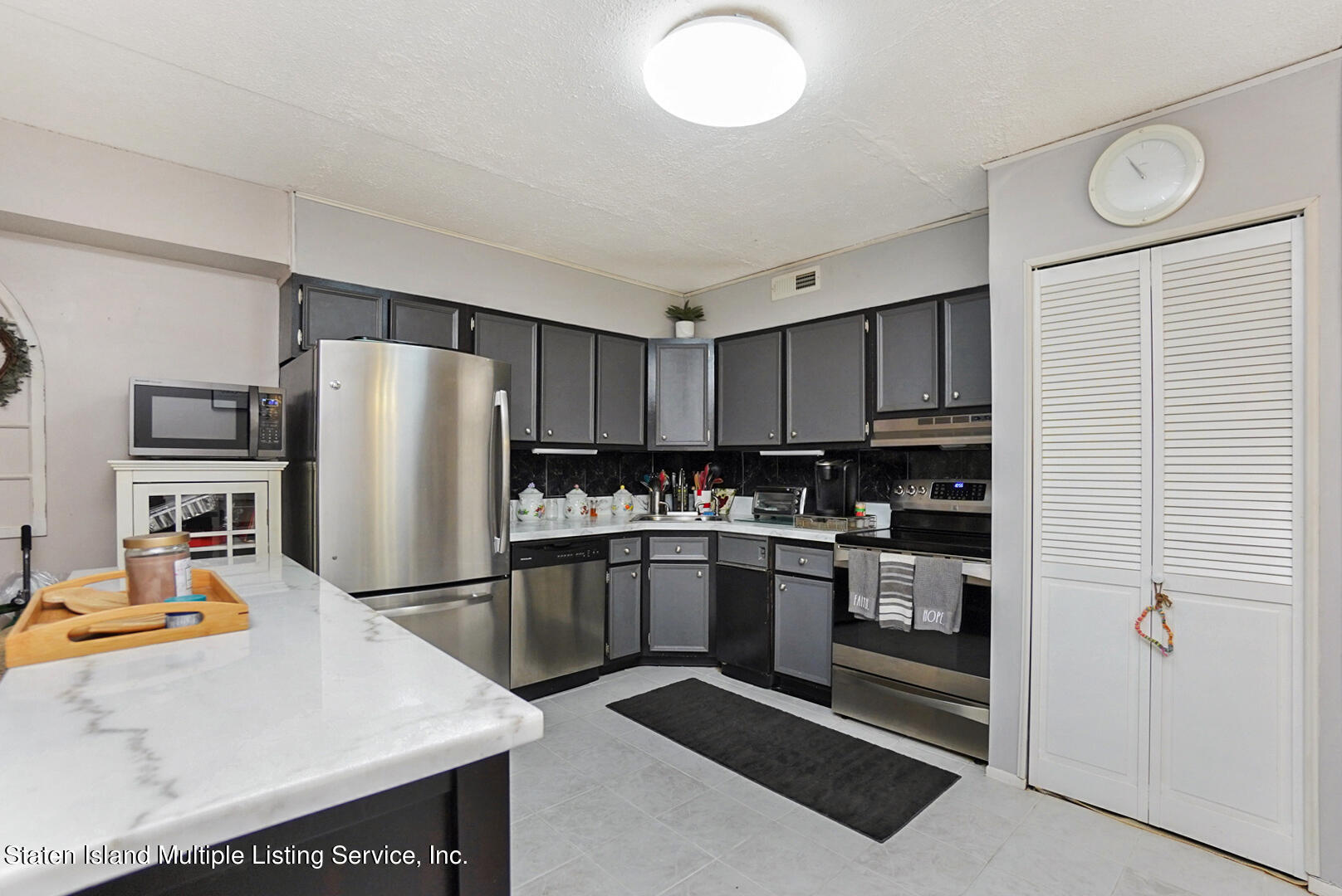 10 Windham Loop, Unit 1A Staten Island, NY 10314 - Photo 8 of 19 a kitchen with refrigerator and white cabinets