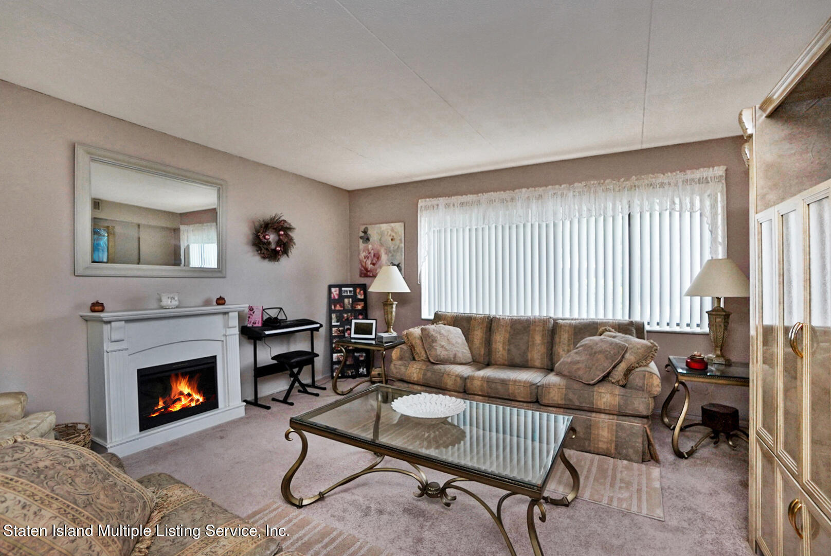 10 Windham Loop, Unit 1A Staten Island, NY 10314 - Photo 10 of 19 a living room with furniture and a fireplace