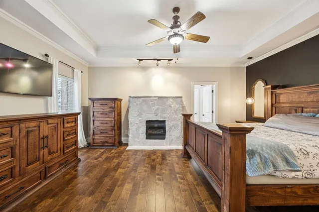 a bedroom with a large bed a flat tv screen and dresser