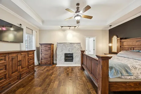 a bedroom with a large bed a flat tv screen and dresser