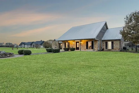 a front view of house with yard barbeque and outdoor seating