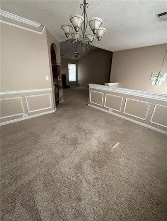 en empty room with windows and fireplace