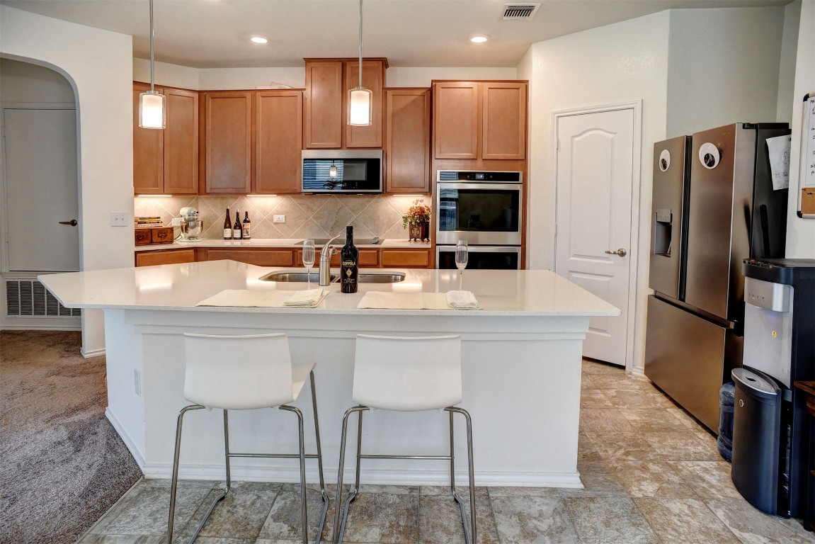 1928 Dragonfly Loop Bastrop, TX 78602 - Photo 1 of 32 a kitchen with stainless steel appliances granite countertop a table chairs sink refrigerator and microwave