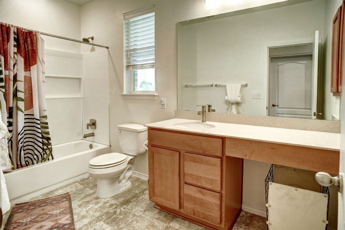 1928 Dragonfly Loop Bastrop, TX 78602 - Photo 11 of 32 a bathroom with a sink toilet a mirror and shower