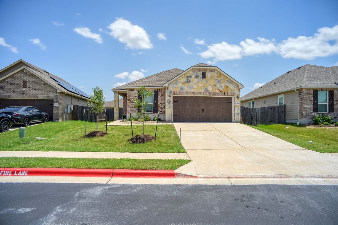 1928 Dragonfly Loop Bastrop, TX 78602 - Photo 12 of 32 a view of yellow house with a big yard and potted plants