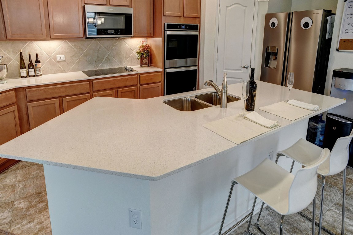 1928 Dragonfly Loop Bastrop, TX 78602 - Photo 19 of 32 a kitchen with stainless steel appliances a refrigerator and a stove top oven