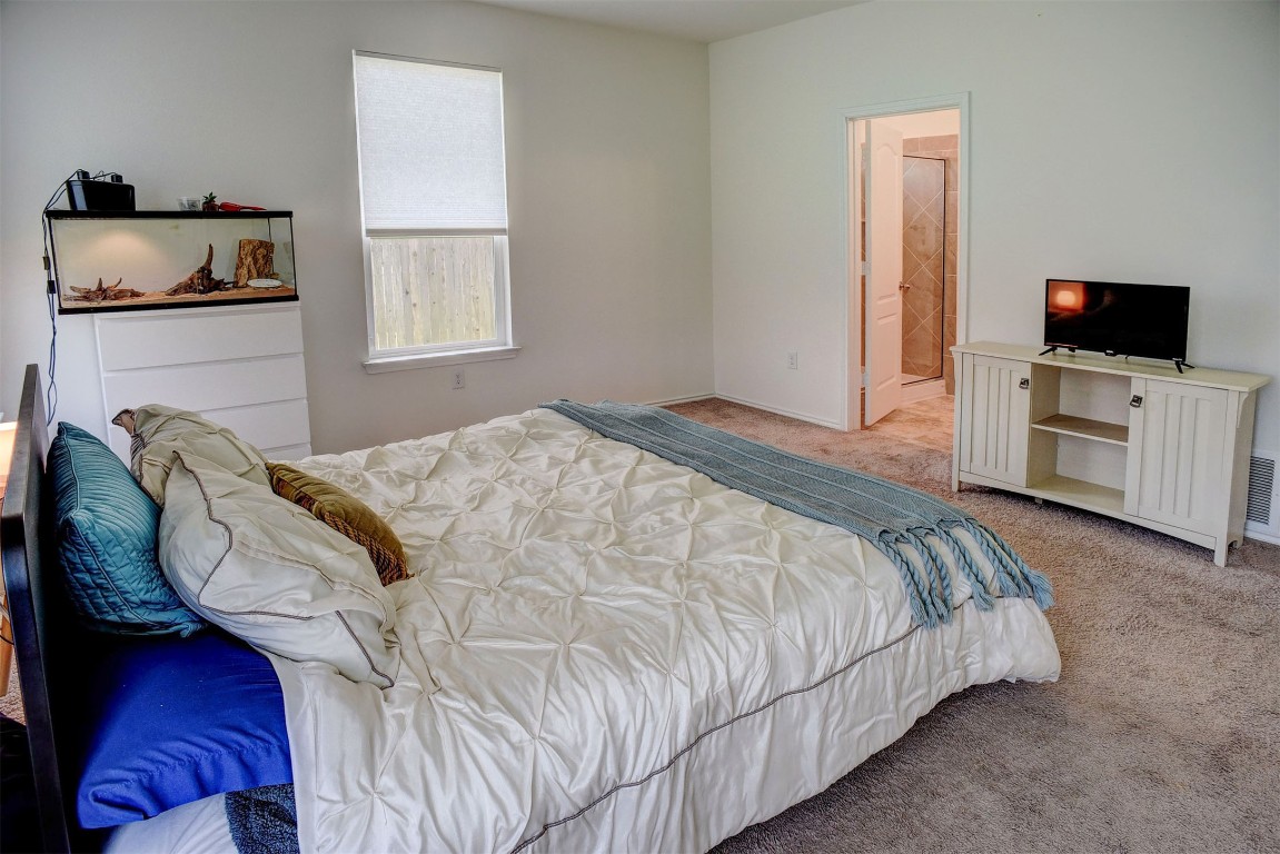 1928 Dragonfly Loop Bastrop, TX 78602 - Photo 21 of 32 a bedroom with a bed and flat screen tv