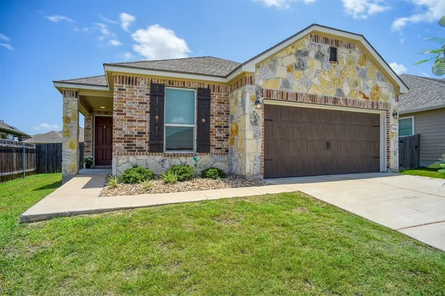 a front view of a house with a garden and yard