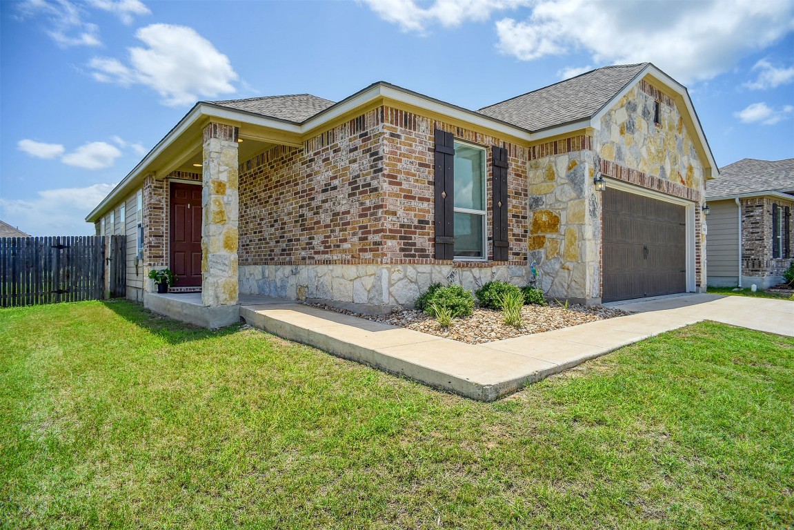 1928 Dragonfly Loop Bastrop, TX 78602 - Photo 30 of 32 a front view of a house with a garden