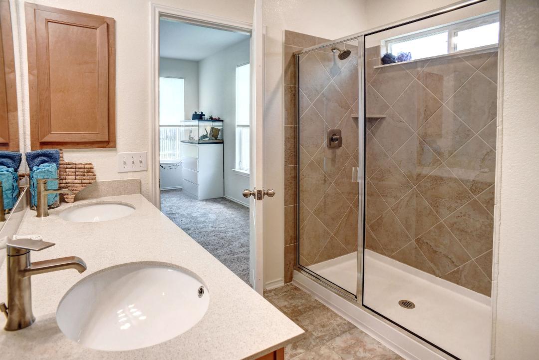 1928 Dragonfly Loop Bastrop, TX 78602 - Photo 4 of 32 Bathroom featuring double vanity and a stall shower