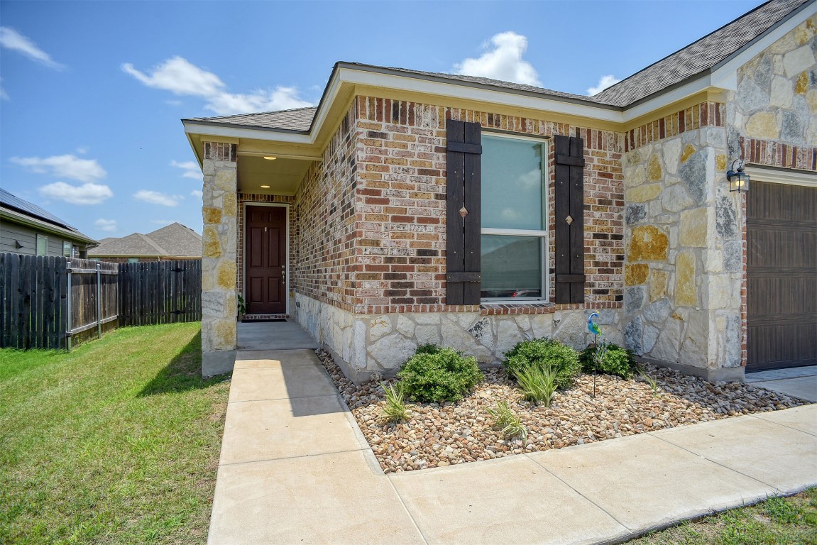 1928 Dragonfly Loop Bastrop, TX 78602 - Photo 8 of 32 Property entrance featuring brick veneer front, double car garage with electric car charger