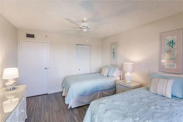 a bedroom with two beds and painting on the wall
