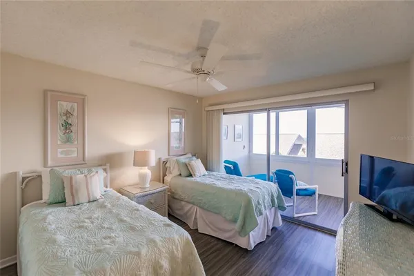 a bedroom with two beds and a large window