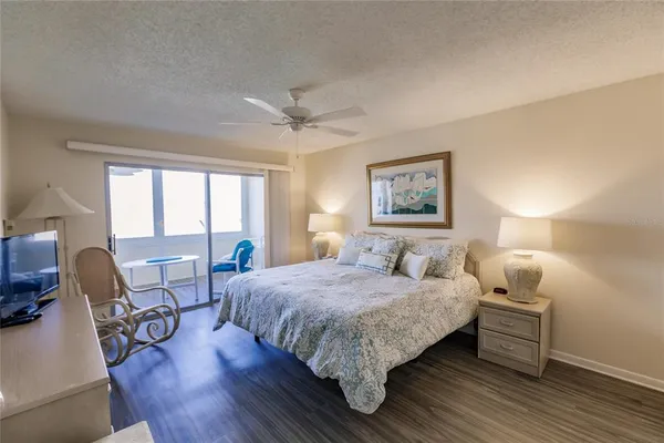 a bedroom with a bed a chair and a large window