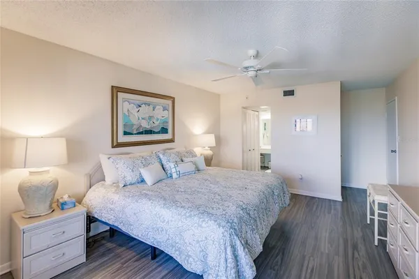 a spacious bedroom with a bed and a chandelier