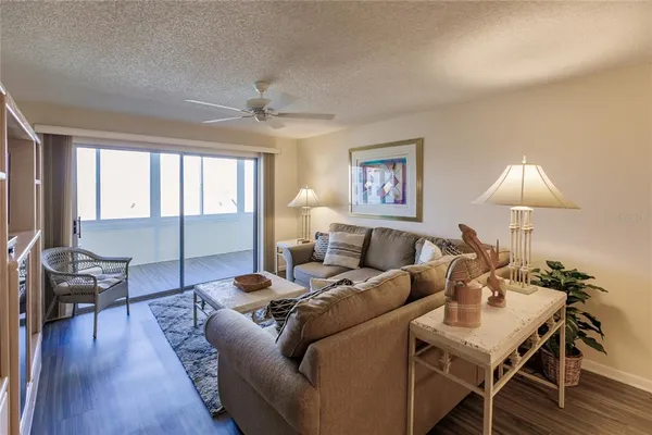 a living room with furniture a lamp and a floor to ceiling window