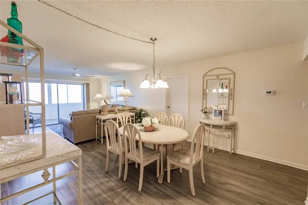 a dining room with furniture a chandelier and wooden floor